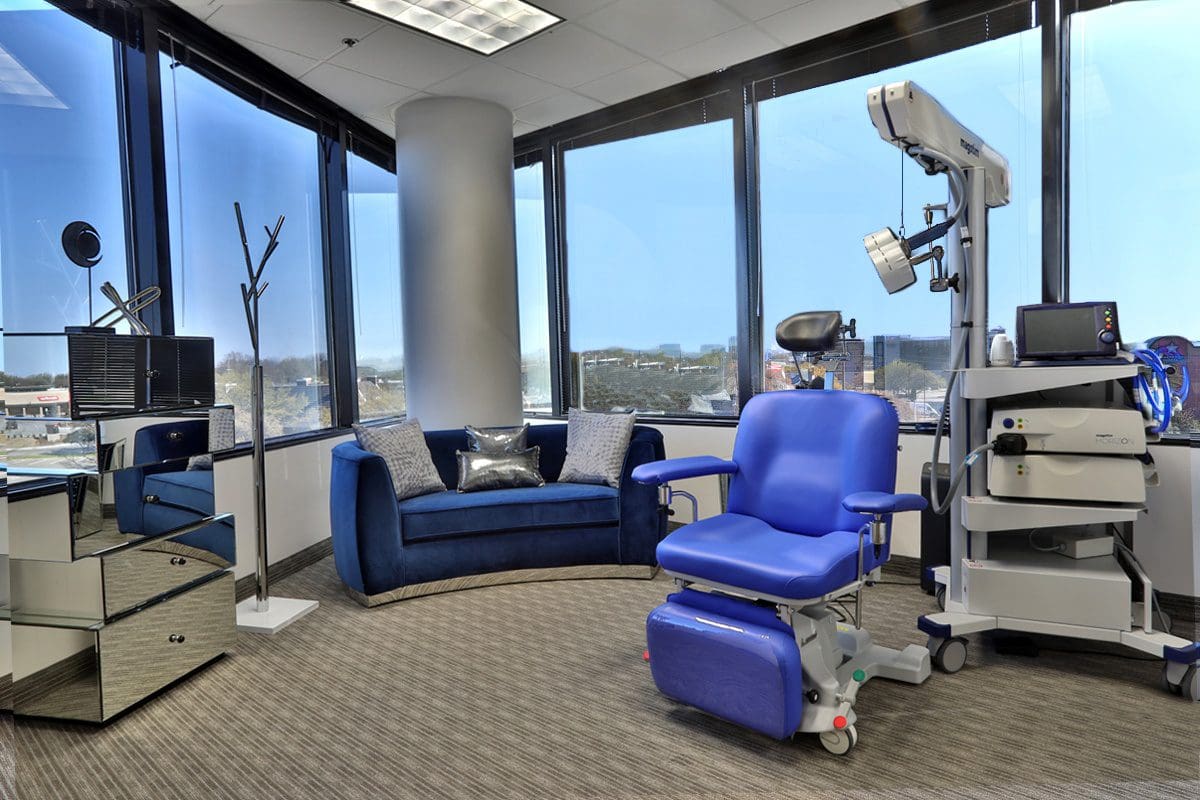 A room with a couch, chair and window.